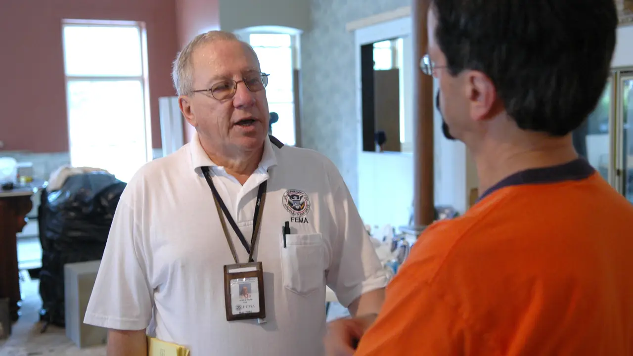 Business owner talking with an inspector inside a damaged building