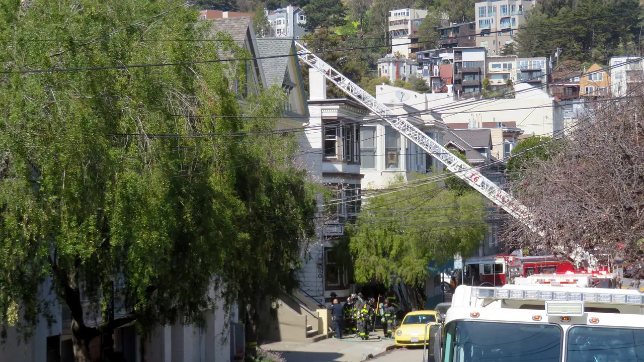 Fire crews and a ladder truck outside a hillside home