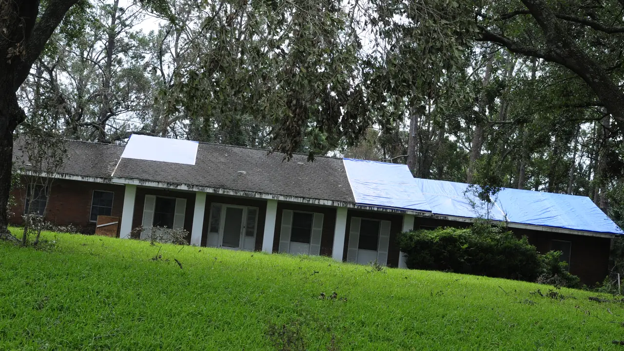 Tarps covering storm damage on an apartment building